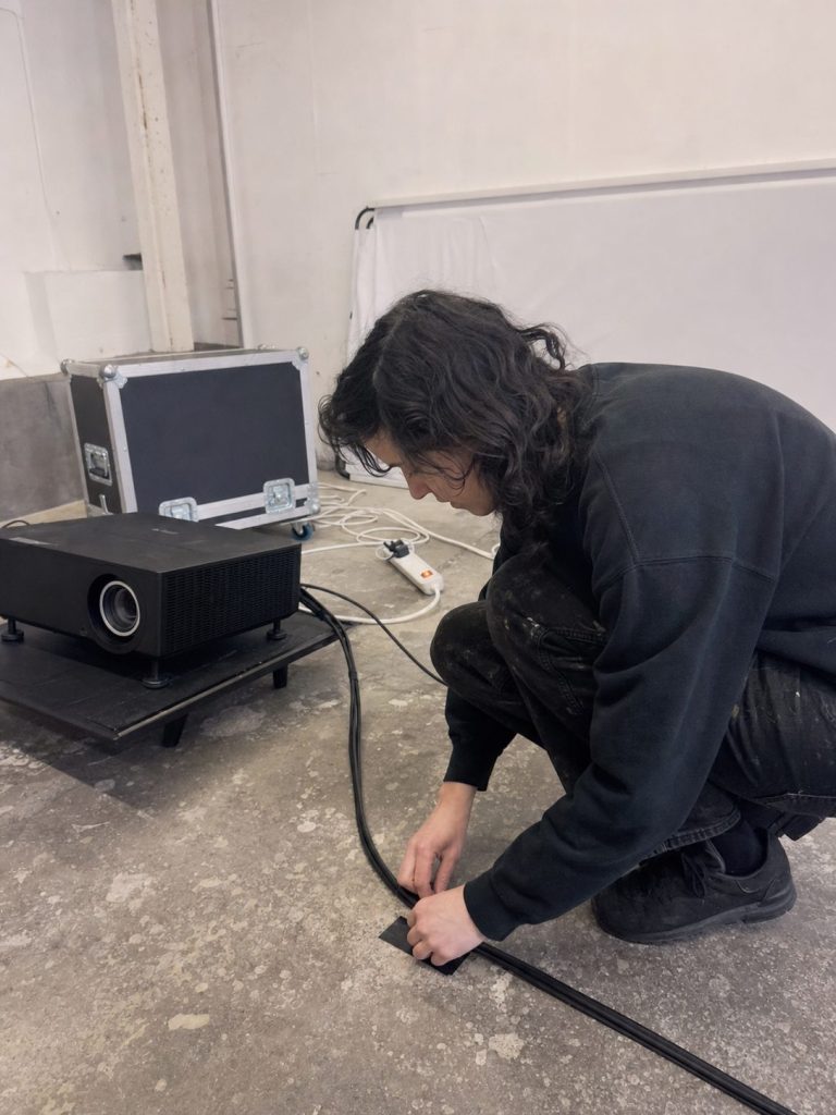 Artist working beside a projector during installation